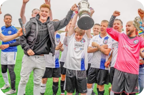 Local football team lifting up a trophy they have won.